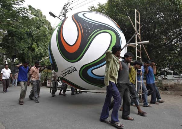 Soccer fans carry a giant replica of the official ball for 2014 FIFA World Cup. Picture: Reuters