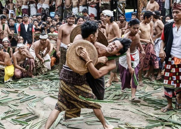 Two Tengananese men fight each other using thorny pandanus leaves. Picture: Getty