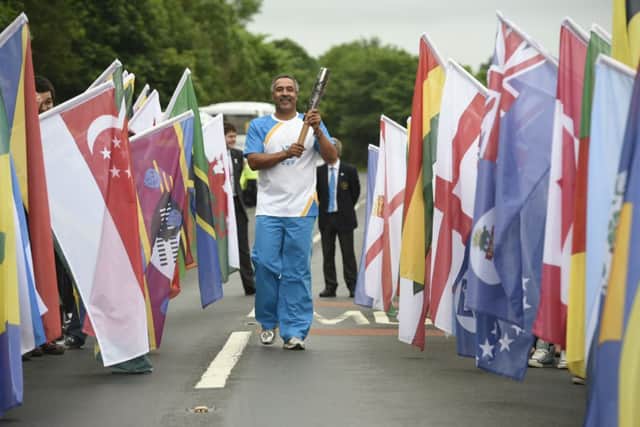 Daley Thompson carrying the Glasgow 2014 Queen's Baton