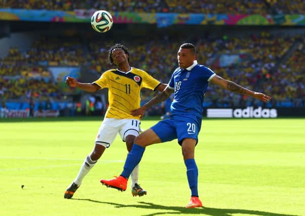 Juan Guillermo Cuadrado of Colombia and Jose Cholevas of Greece fight for the ball. Picture: Getty