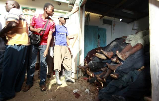 Residents of Mpeketoni look at the bodies of people killed when unidentified gunmen attacked the coastal town. Picture: Reuters