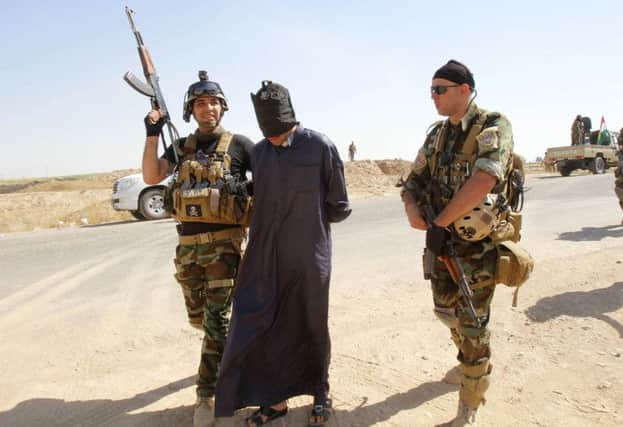 A suspected Isis militant is detained by Kurdish security forces. Picture: Reuters