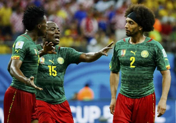 Cameroons Achille Weboc tries to separate Benjamin Moukandjo and Benoit AssouEkotto. Picture: Reuters