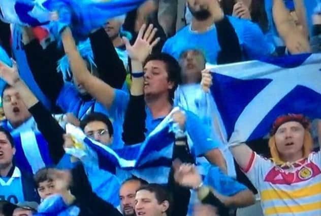 The Scotland fan celebrates with jubilant Uruguay fans in the Corinthians Arena. Picture: Contributed