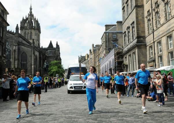 The Commonwealth Games Queens Baton Relay being carried through Edinburgh City Centre. Picture: TSPL
