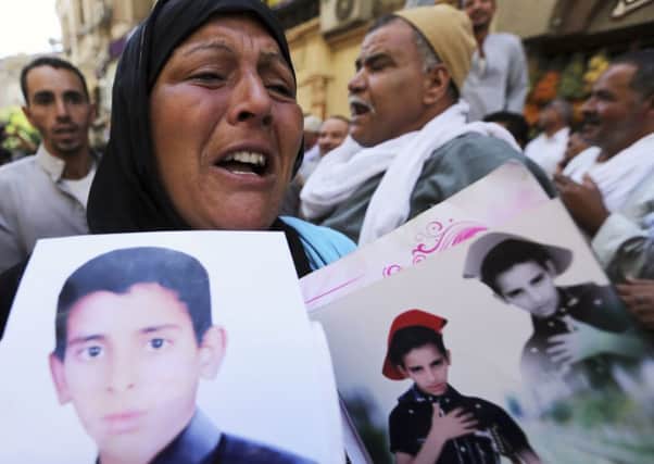 A woman holding photos of her son, an accused supporter of ousted Egpytian President Mursi. Picture: Reuters