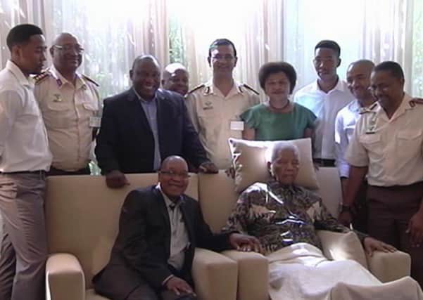 President Jacob Zuma sits beside the ailing Nelson Mandela in April last year. Picture: AP