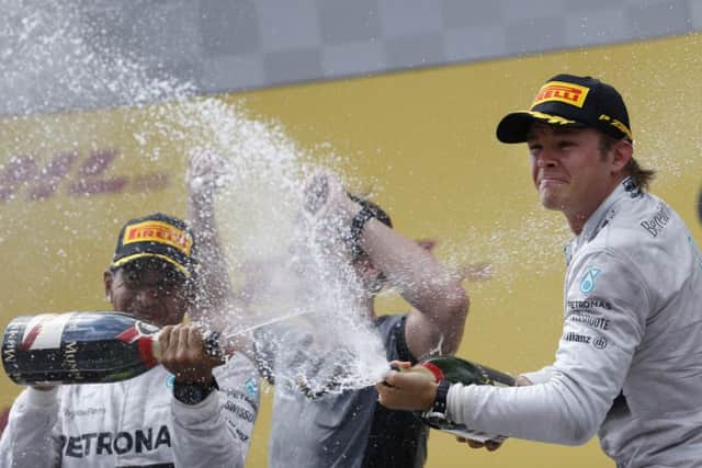 Lewis Hamilton, left, and Nico Rosberg, spray champagne after taking the first two places in Austria. Picture: AP
