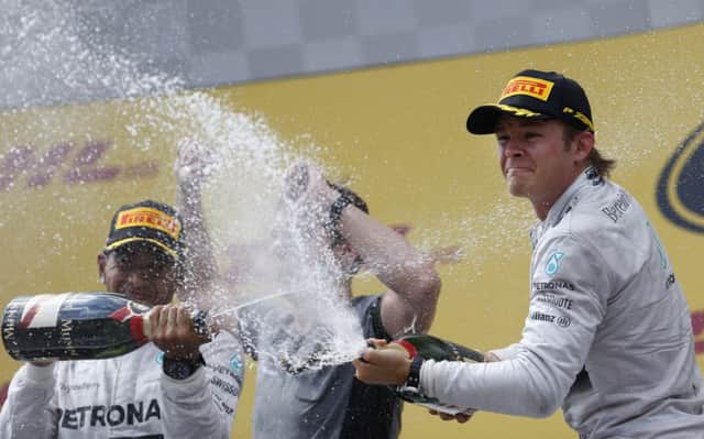 Lewis Hamilton, left, and Nico Rosberg, spray champagne after taking the first two places in Austria. Picture: AP