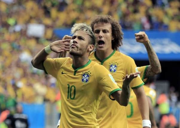 Neymar takes the acclaim of the home support and team-mate David Luiz after his opener last night. Picture: Getty