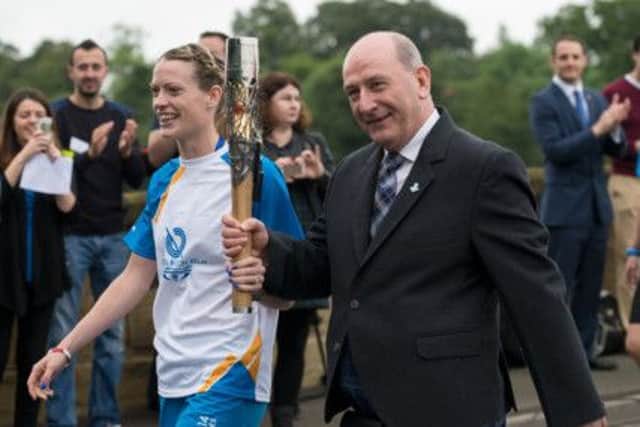 Michael Cavanagh, right, takes the Queens Baton with 400m hurdles runner Eilidh Child in Coldstream