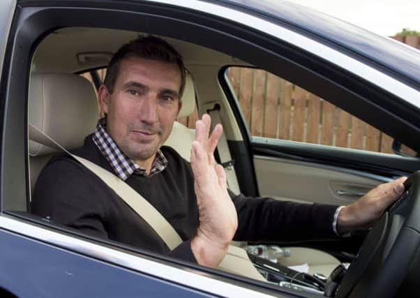 Alan Stubbs waves as he leaves the Hibernian training centre at East Mains. Picture: SNS