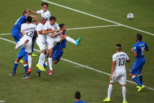 Diego Godin of Uruguay, top, soars above the opposition to score against the Italians. Picture: Getty