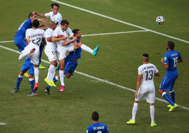Diego Godin of Uruguay, top, soars above the opposition to score against the Italians. Picture: Getty
