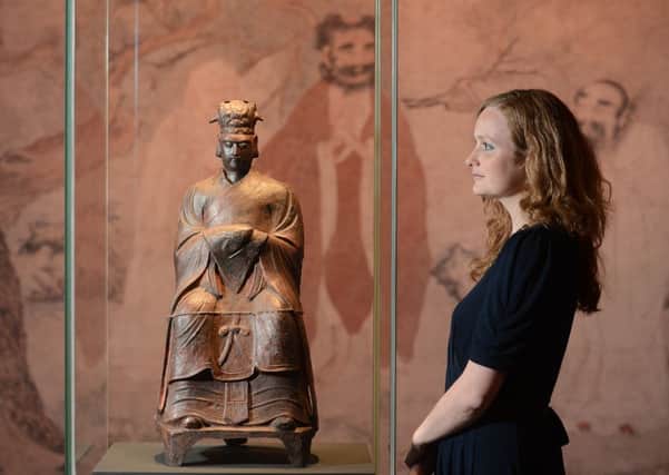 Esme Haigh views a cast iron statue of Wenchang, God of Literature. Picture: Neil Hanna