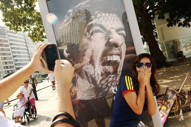A woman takes a photo next to a Suarez ad on Copacabana Beach. Picture: Getty