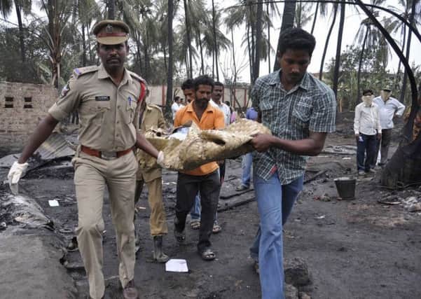 A police officer and local people remove a victim from the debris. Picture: Reuters