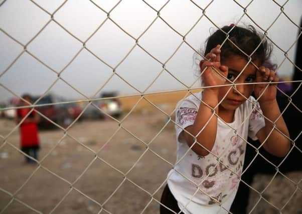 An Iraqi child waits with her family outside a temporary displacement camp. Picture: Getty