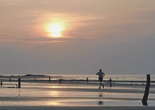 A jogger running against a sunset at Lossiemouth West Beach. Picture: Walter Baxter
