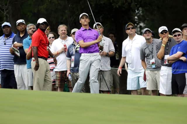 Oliver Goss watches his shot from the 18th fairway. Picture: AP