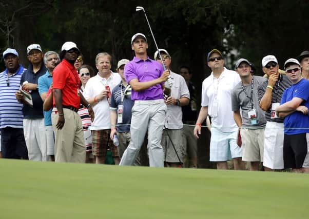 Oliver Goss watches his shot from the 18th fairway. Picture: AP