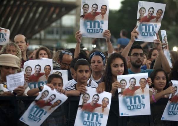 Israelis hold a poster showing the three missing teens as they attend a rally under the slogan Bring Our Boys Home. Picture: Getty