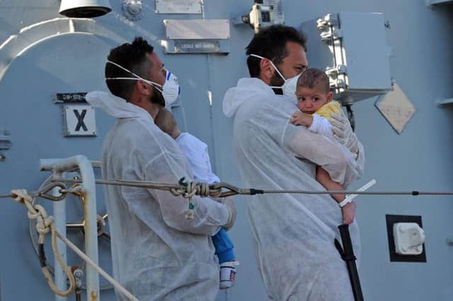 Italian rescuers holds babies saved from the ship in the port of Pozzallo, Sicily. Picture: Getty