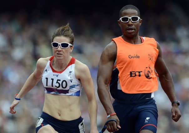 Libby Clegg runs with her guide Mikail Huggins in the 100m event during the London 2012 Paralympics. Picture: AFP/Getty