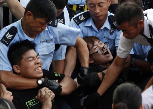Strong-arm tactics of police in Hong Kongs financial district, where a street sit-in was taking place. Picture: AP