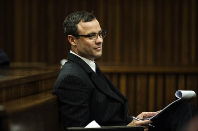 Oscar Pistorius appears relaxed as he takes notes at his trial yesterday. Picture: Reuters