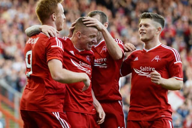 Jonny Hayes (2nd left) is mobbed by his Aberdeen team-mates as they celebrate his goal. Picture: SNS