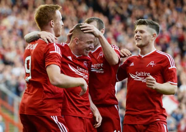 Jonny Hayes (2nd left) is mobbed by his Aberdeen team-mates as they celebrate his goal. Picture: SNS