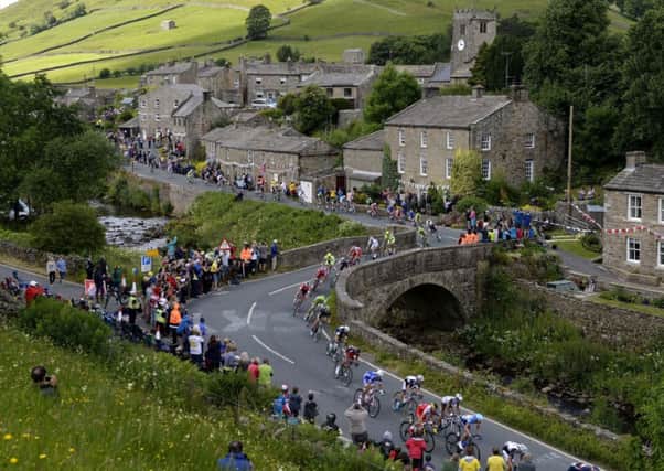 The Peloton passes through the village of Muker, Yorkshire during the 2014 Tour de France. Picture: PA