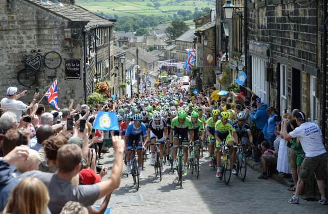 The peloton rides up Main Street as stage two of the Tour de France passes through Haworth. Picture: PA