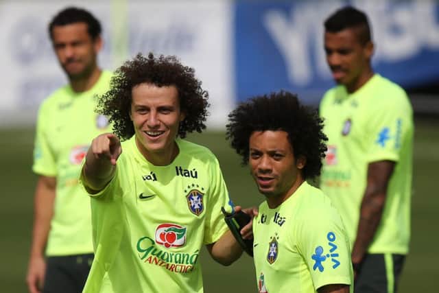 David Luiz, left, talks to team-mate Marcelo during yesterdays final preparations ahead of their semi-final. Picture: AP