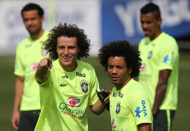 David Luiz, left, talks to team-mate Marcelo during yesterdays final preparations ahead of their semi-final. Picture: AP