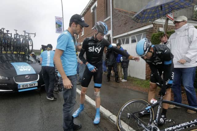 Chris Froome gestures to his teammate Xabier Zandio, right, as he gets up after a third crash in two days. Picture: AP