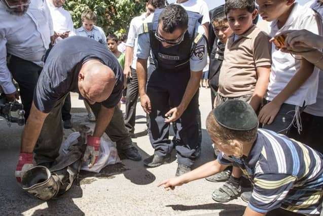 Israeli bomb disposal experts inspect a rocket fired by Palestinian militants. Picture: AFP