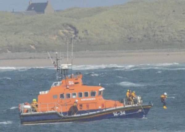 The moment when Crewman John Chalmers leaps from the RNLI lifeboat as Scott MacLean, 12, was about to go under. Picture: RNLI