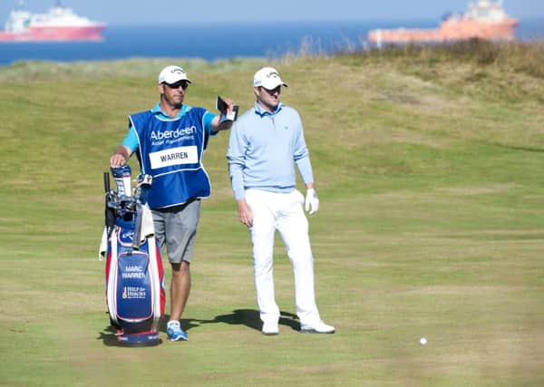 Marc Warren and his caddy discuss the best line playing the 18th hole during day two of the Aberdeen Asset Management Scottish Open. Picture: PA