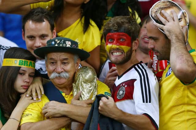 A Germany fan reacts while surrounded by dejected Brazil fans after Germany's 7-1 win. Picture: Getty