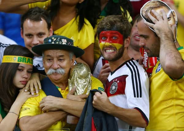 A Germany fan reacts while surrounded by dejected Brazil fans after Germany's 7-1 win. Picture: Getty