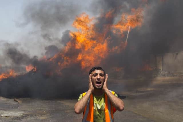 Palestinian firefighters try to extinguish fire at UN storehouse after an Israeli military strike. Picture: Getty
