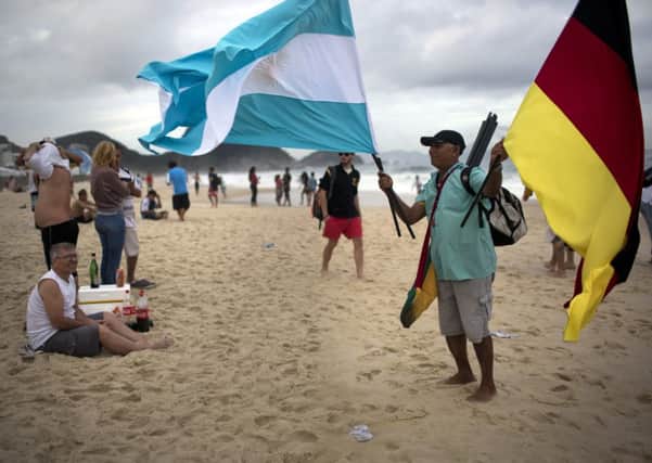 A street vendor sells Argentine and German flags on Copacabana beach ahead of Sunday's World Cup final. Picture: AP