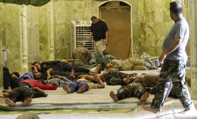 Shiite volunteers in support of the Iraqi army take a break from hostilities and sleep inside the Imam alAskari shrine. Picture: Reuters
