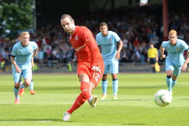 Gary Harkins strikes his penalty, scoring from the rebound. Picture: SNS