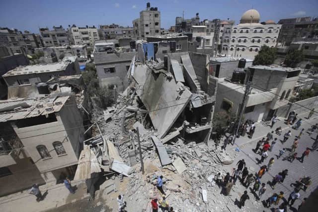 Palestinians examine the ruins of a house in Gaza, which police said was destroyed in an airstrike. Picture: Reuters