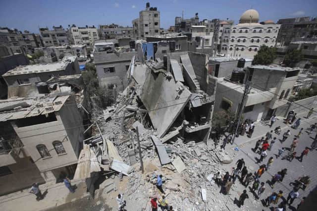 Palestinians examine the ruins of a house in Gaza, which police said was destroyed in an airstrike. Picture: Reuters