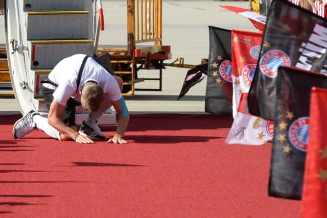 Bastian Schweinsteiger kneels down to kiss the ground after the World Cup-winning squad arrived back home. Picture: Getty