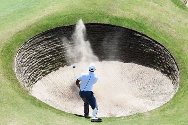 Tiger Woods chips from a bunker on to the 18th green on his way to an opening 69. Picture: Getty